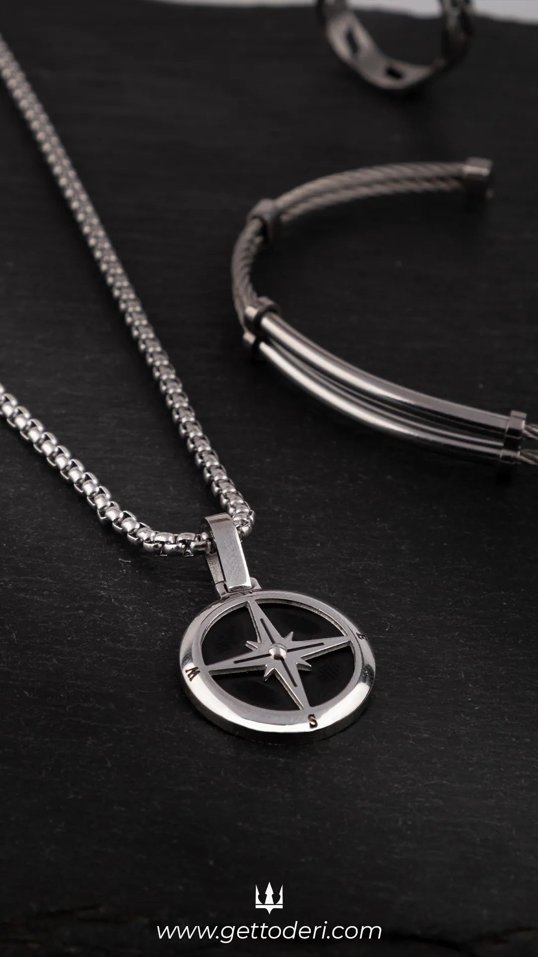 Gümüş rengi pusula desenli metal kolye, siyah zeminde
