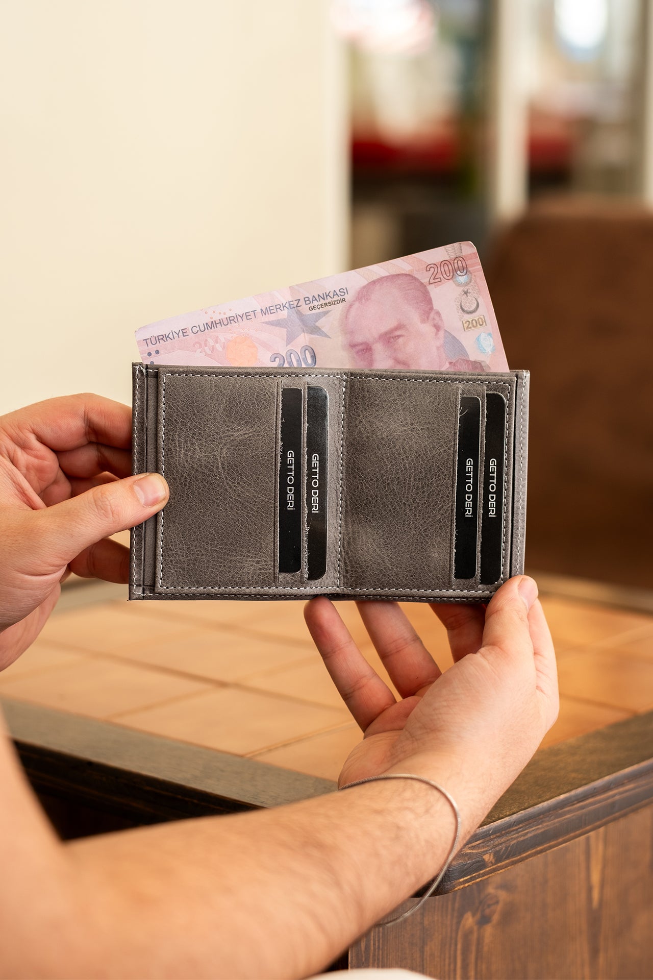 Gri deri cüzdan, kart bölümleri ve Türk lirası banknotuyla