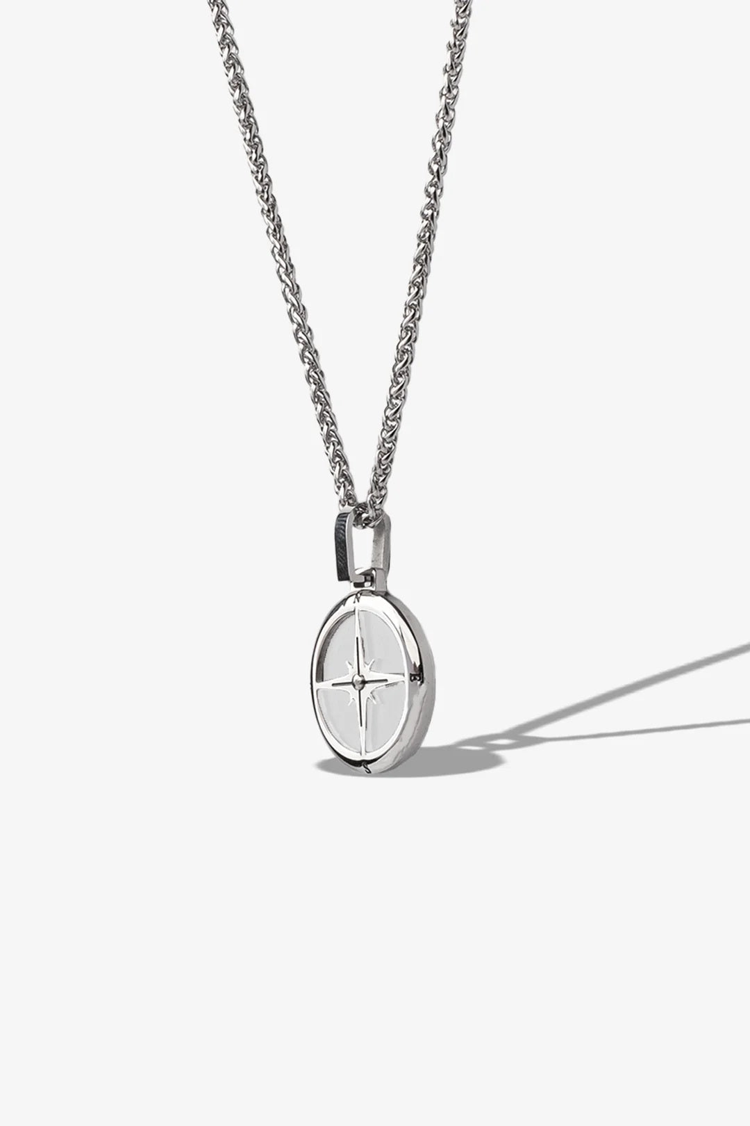 Gümüş renkli metal kolye, oval asma ve yıldız desenli yüzey
