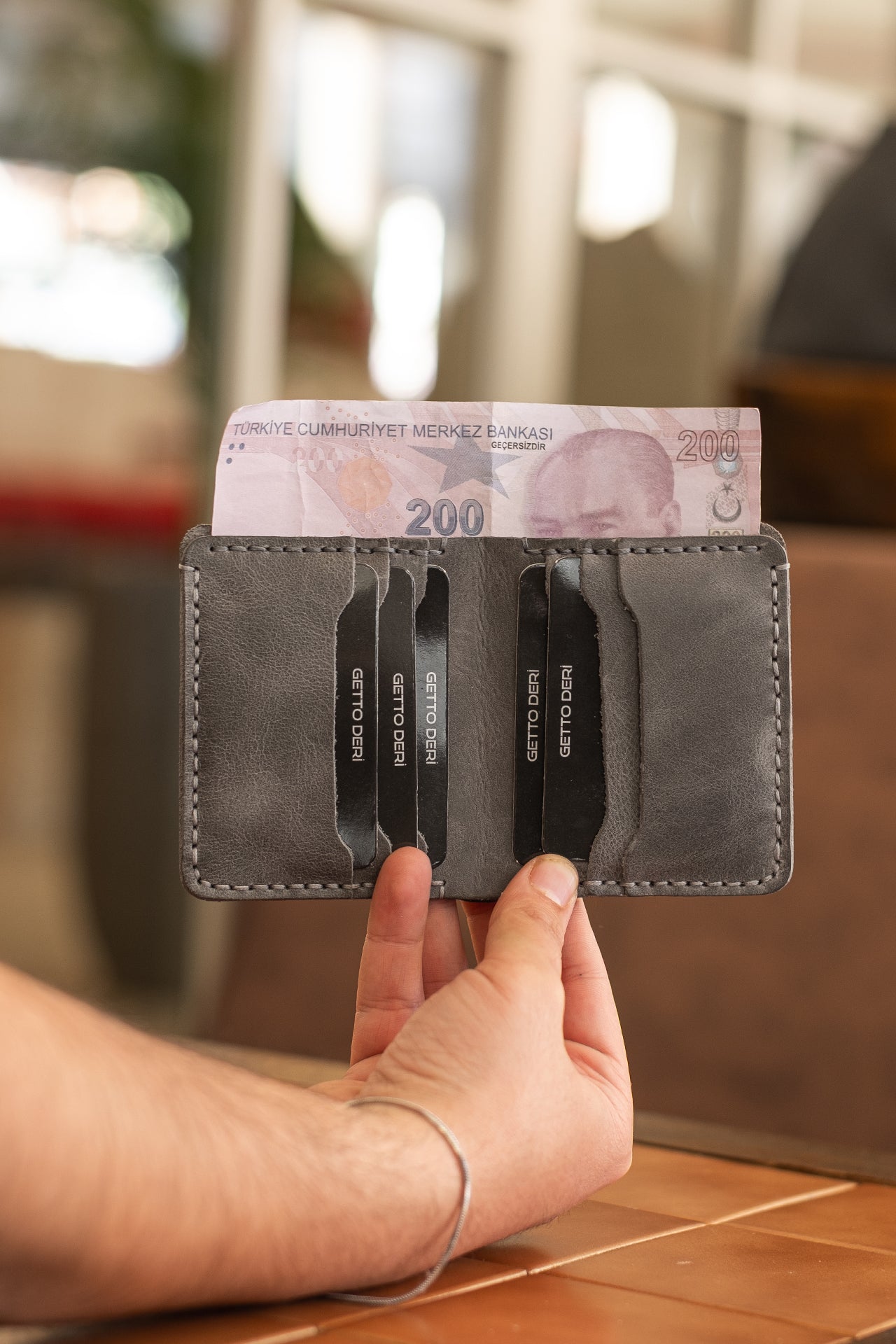 Gri deri kartlık, para ve kart bölümleriyle praktik kullanım