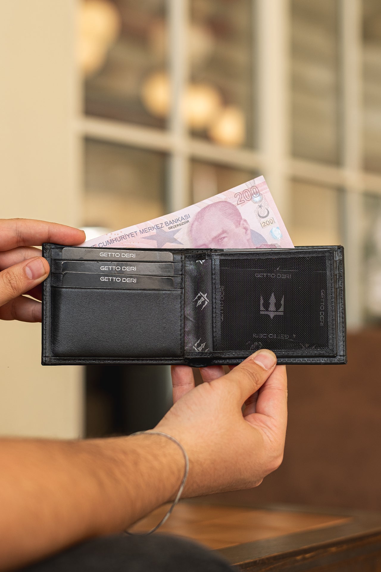 Siyah deri cüzdan, kartlık ve para bölmesiyle açık tutulmuş