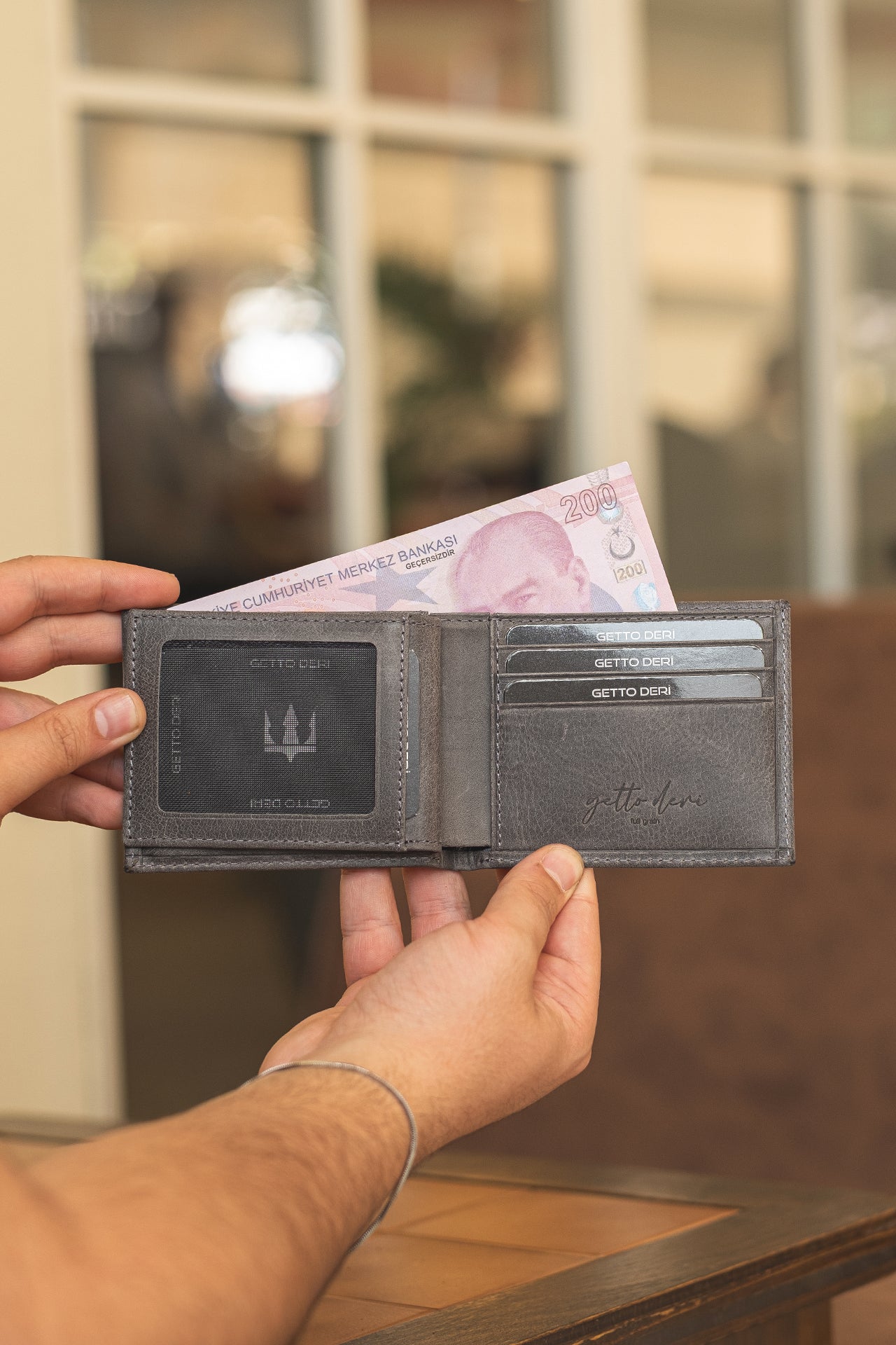 Koyu gri deri cüzdan, kart bölümlü ve para içeren açık tasarım