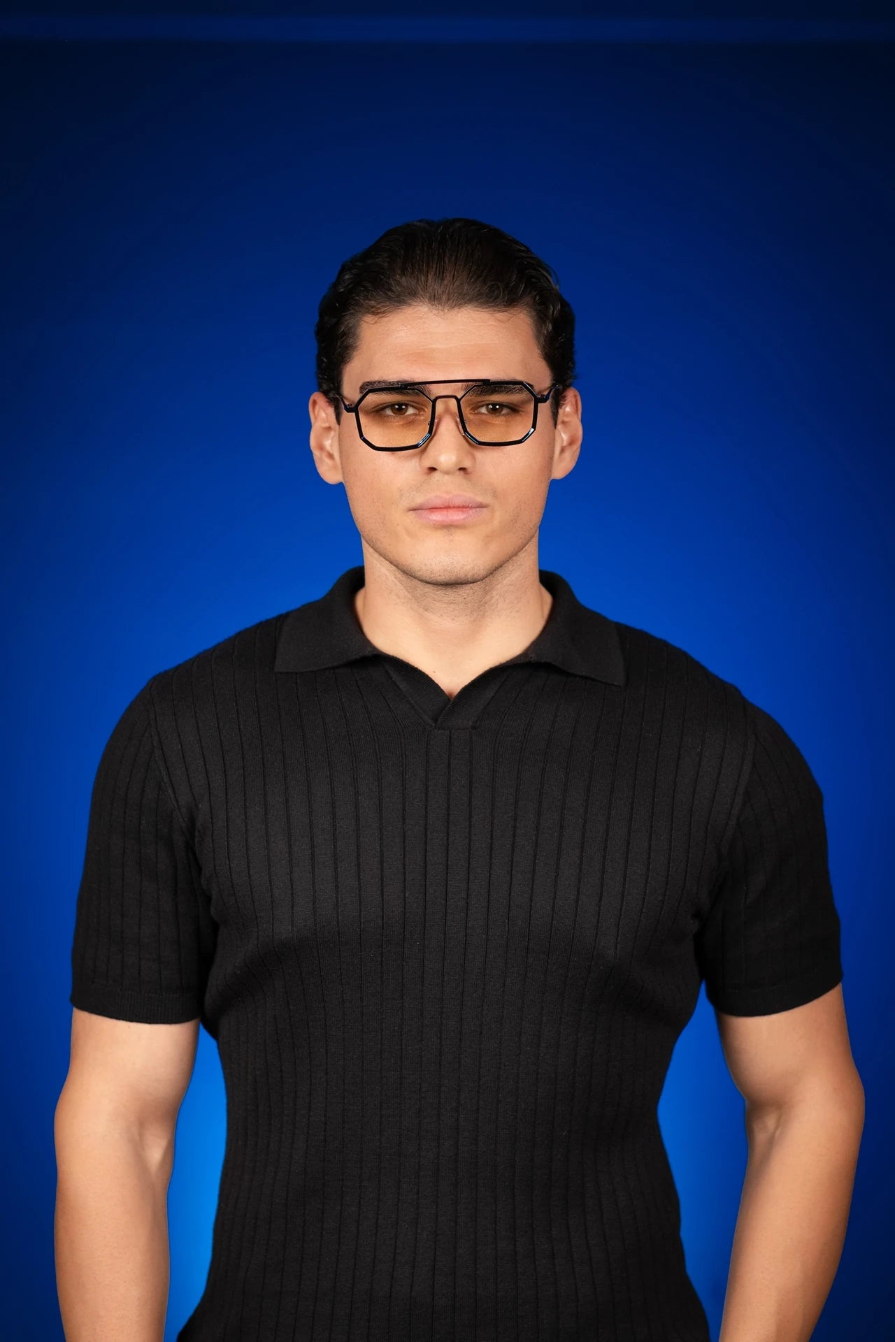 Siyah ribbed polo tişört giyen erkek, mavi arka plan