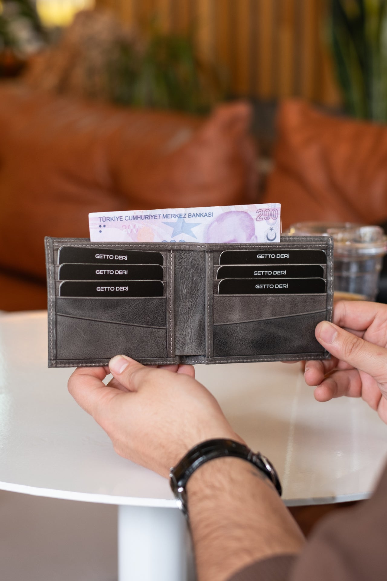 Koyu gri deri cüzdan, kartlık ve para bölmesiyle açık tutulmuş