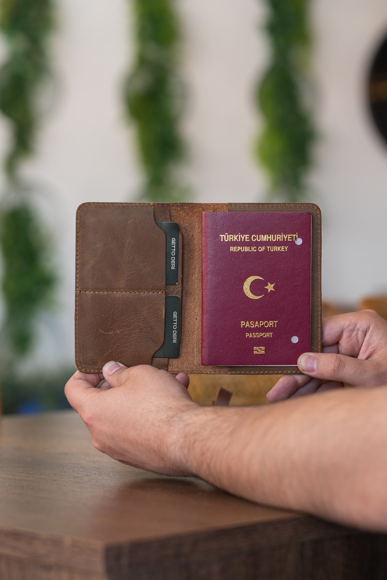 Kahverengi deri pasaport kılıfı, kart bölmesi ve pasaport içeren seyahat aksesuarı