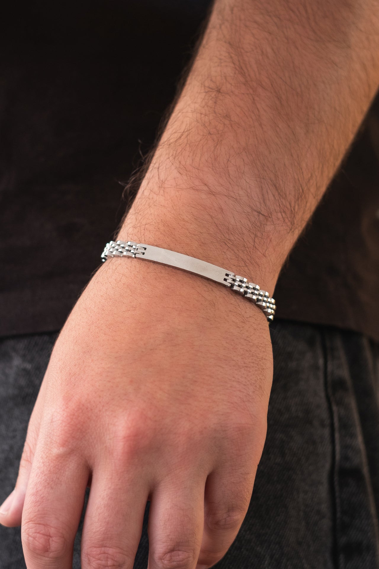 Gümüş renkli metal bileklik, erkek kolunda şık tasarımlı