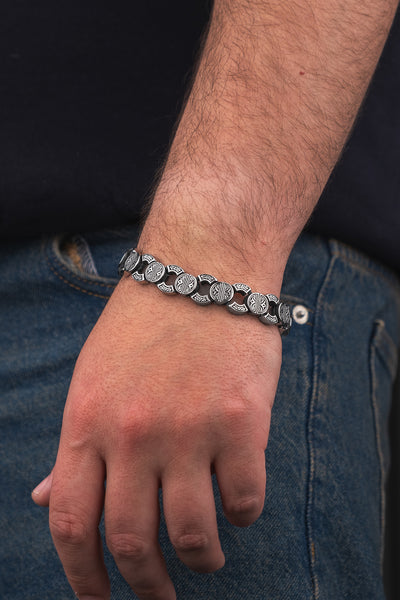 Gümüş renkli, desenli metal bileklik erkek kolunda