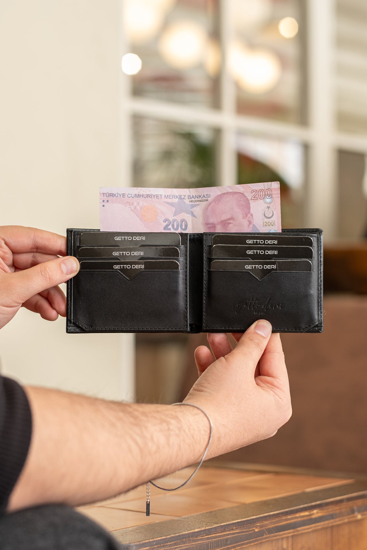 Siyah deri cüzdan, kart bölümleri ve para bölmesiyle açık tutuluyor
