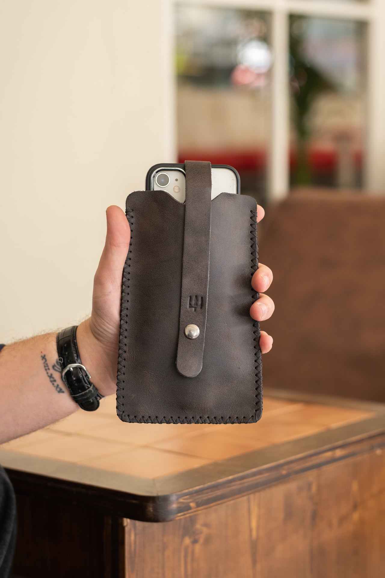 Koyu renk deri telefon kılıfı, el yapımı dikiş detaylı, fermuarlı kapak