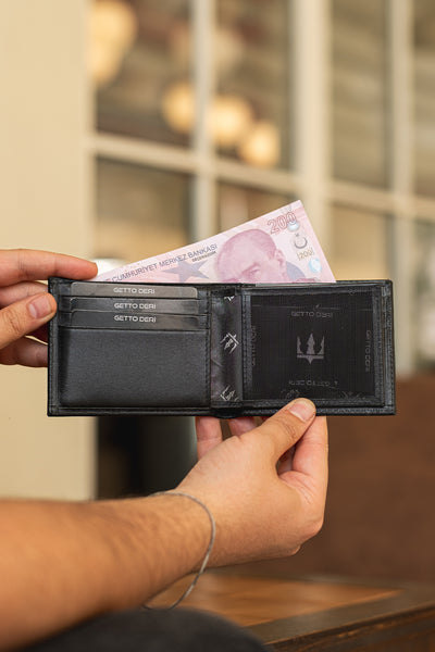 Siyah deri cüzdan, kartlık ve para bölmesiyle açık tutulmuş