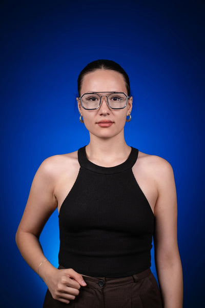 Mavi arka plan önünde siyah kolsuz üst giyen kadın