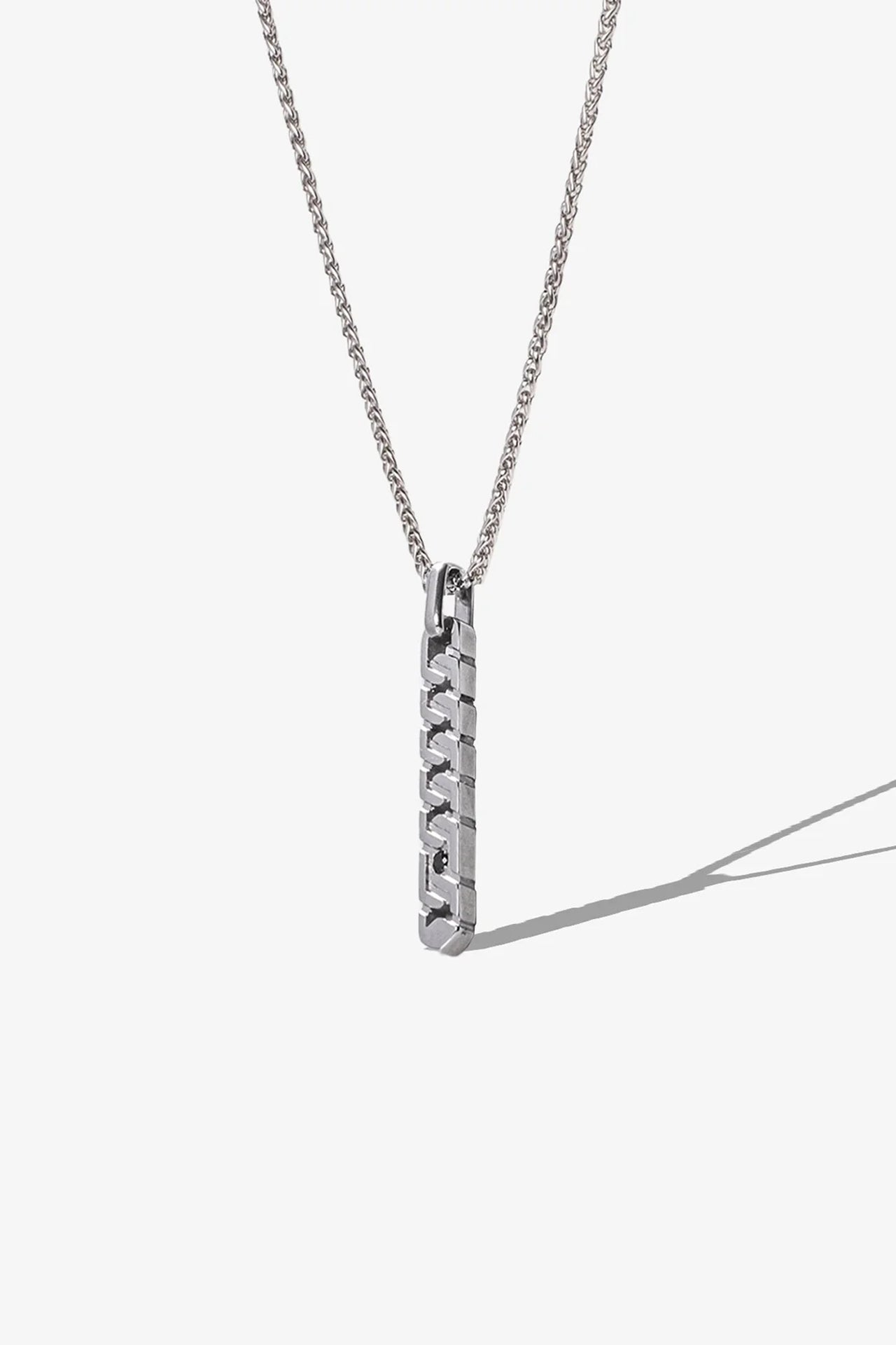 Gümüş renkli metal kolye, uzun zincir ve geometrik asma detayıyla modern tasarım