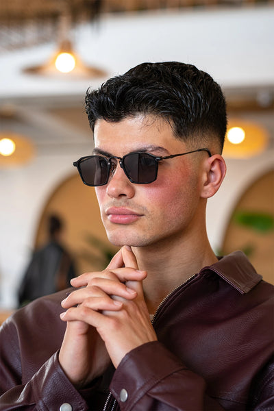 Koyu renkli kare güneş gözlüğü, deri ceket giyen erkek model
