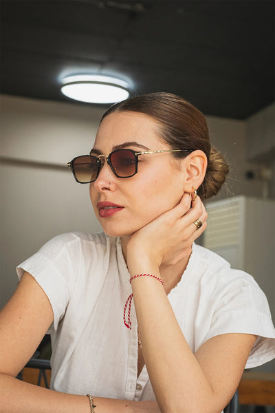 Kare çerçeveli siyah güneş gözlüğü, altın detaylı, koyu lensli