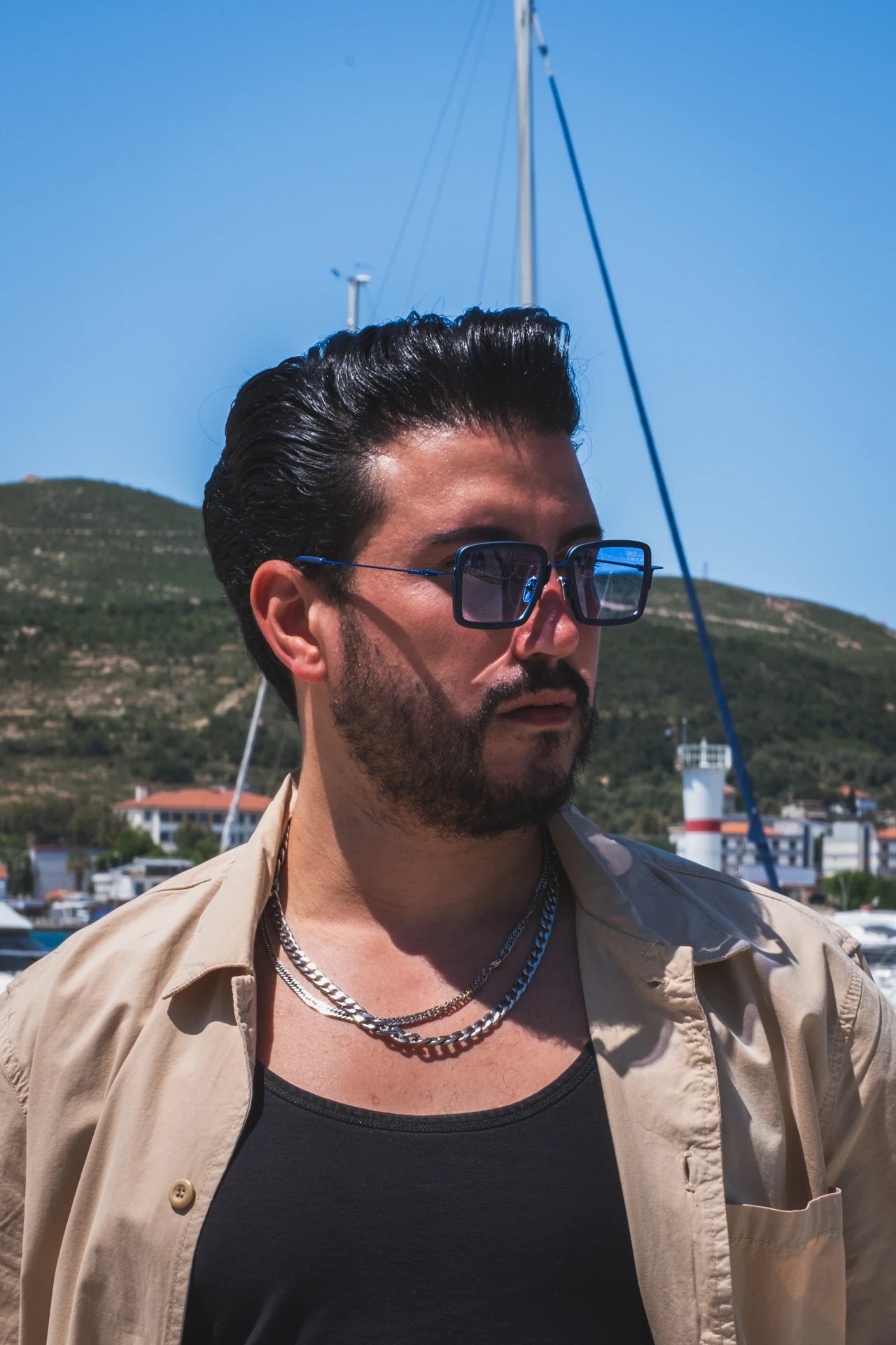 Güneş gözlüğü takan adam, açık havada, dağ ve tekne arka planında