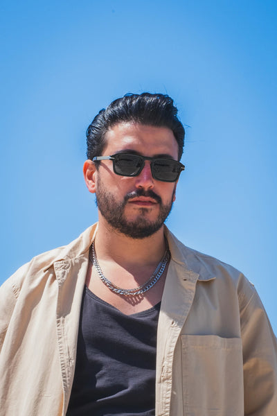 Siyah kare güneş gözlüğü, açık mavi gökyüzü önünde erkek model