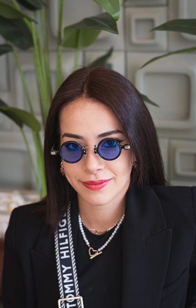 Mavi lensli yuvarlak güneş gözlüğü, siyah çerçeveli ve altın detaylı